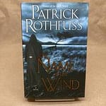 book cover, illustration. hooded figure walks away into a gray landscape